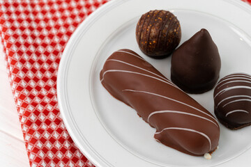 Sweet chocolate candies on white plate close up