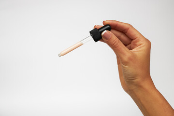 hand with dropper, beauty product