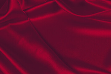 Red silk or satin luxury fabric texture can use as abstract background. Top view.