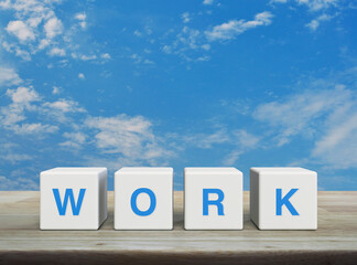 WORK letter on white block cubes on wooden table over blue sky with white clouds, Business teamwork communication concept