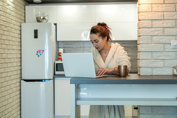 young specialty girl working remotely from home over a cup of coffee during coronavirus.