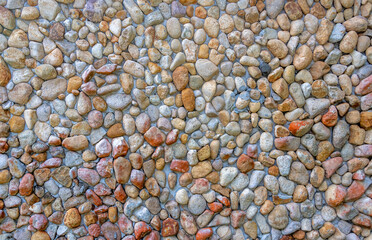 Rounded pebbles held by concrete in a wall suitable for background
