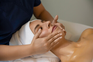 Therapist giving face massage to a woman