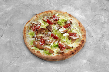 Delicious pizza Caesar style with white sauce, chicken, parmesan, egg, cherry tomatoes and fresh lettuce at wooden background. Restaurant pizzeria menu with delicious taste pizza Caesar.