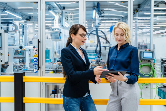 Businesswomen using digital tablet at electrical industry