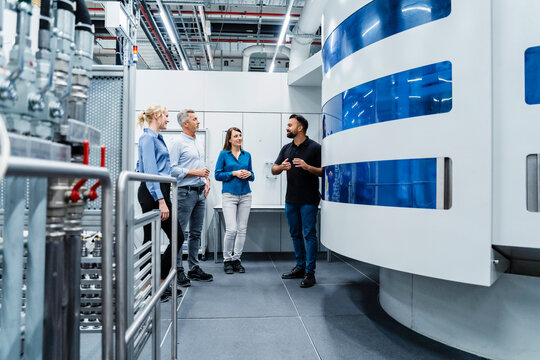 Engineer discussing with businessman and businesswomen at automated industry