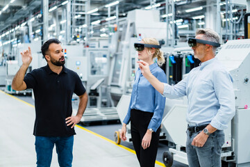 Coworkers with augmented reality glasses working at industry