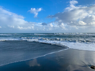 Fototapeta na wymiar Seascape, white clouds on the blue sky reflection, sea surface, sand beach