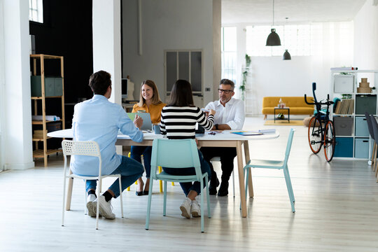 Colleagues sitting at desk working in office