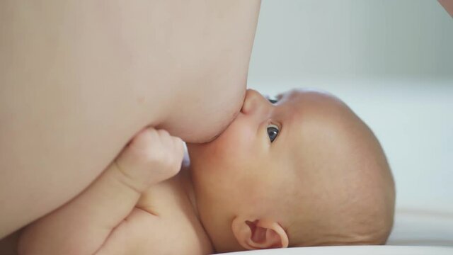 breastfeeding.close up.mother feeds baby with breast milk in bed.good appetite.