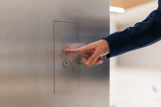 Businessman using elevator push button