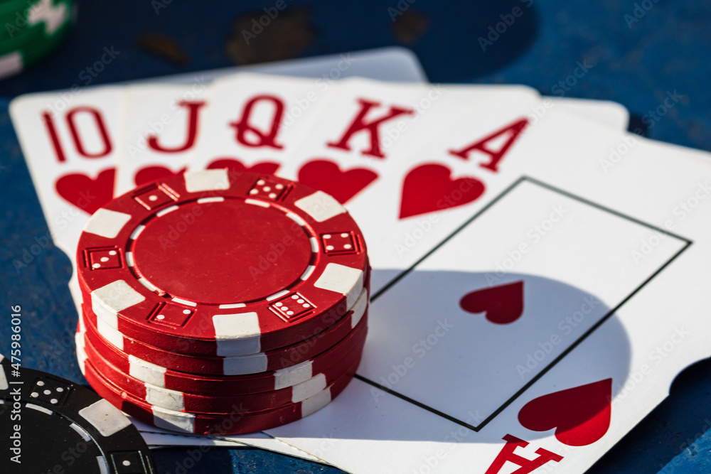 Sticker Closeup of poker chips and playing cards on a rough blue surface