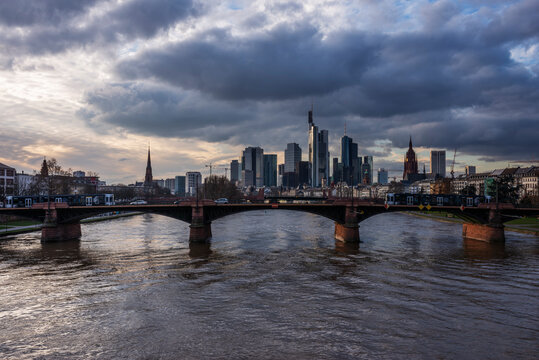Germany, Hesse, Frankfurt, Cloudy sky over Ignatz Bubis Bridge at dusk with downtown skyline in background
