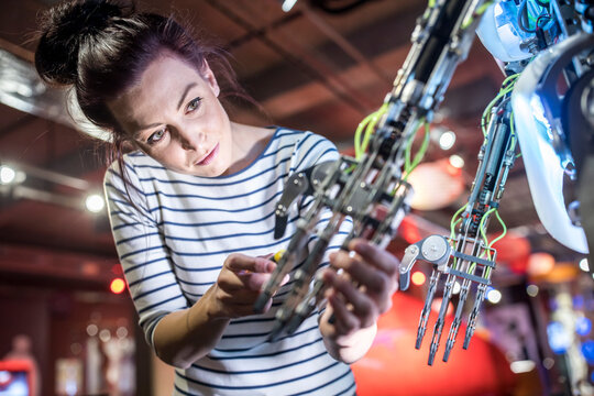 Engineer repairing robotic arm in workshop