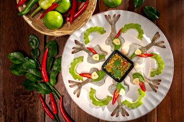Raw Shrimp in fish sauce with many herbs. A delicious recipe from Asia and spices ingredients for cooking on wooden table background, Thai food, Asian foods, Thailand restaurant menu