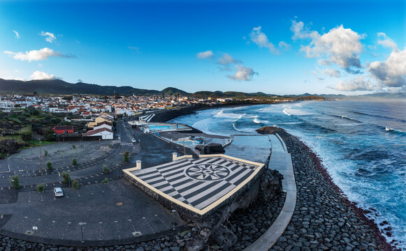 Portugal, Azores, Ribeira Grande, Drone view of parking lot at edge of coastal town on Sao Miguel Island