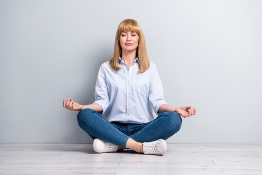 Full size photo of lady representative rest office meditate quiet sit floor legs crossed position isolated grey color background