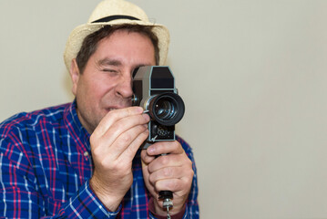Man with Camera.cameraman make film on a retro camera.man with a plaid shirt filming with a Super 8...