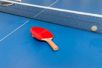 Dusty Paddle, tennis ball on blue ping pong table close up.Blue table tennis or ping pong.Selective focus.Closeup.