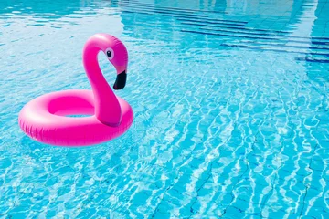 Zelfklevend Fotobehang Flamingo plastic. Pink inflatable flamingo in pool water for beach background. Trendy summer concept. © Maksym