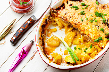 Baked meat with potatoes and cheese.