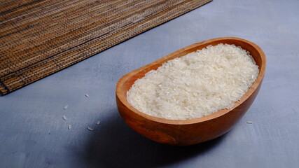 Rice in an oval wooden bowl and some kitchen ornaments neatly and beautifully arranged on a table. food and beverage concept. 