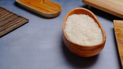 Rice in an oval wooden bowl and some kitchen ornaments neatly and beautifully arranged on a table. food and beverage concept. 