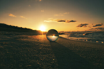 Glass globe on the beach of the Baltic Sea in Zingst in which the landscape is depicted.