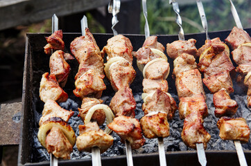 Marinated shashlik preparing on a barbecue grill over charcoal. Traditional Russian shashlik on a barbecue skewer