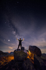 Male hiker at night facing the Milky Way