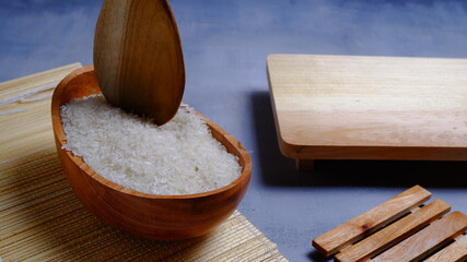 Rice in an oval wooden bowl and some kitchen ornaments neatly and beautifully arranged on a table. food and beverage concept. 