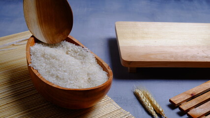 Rice in an oval wooden bowl and some kitchen ornaments neatly and beautifully arranged on a table. food and beverage concept. 
