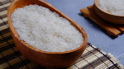 Rice in an oval wooden bowl and some kitchen ornaments neatly and beautifully arranged on a table. food and beverage concept. 