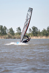 Windsurfer surfing on a windy summertime day at the river.