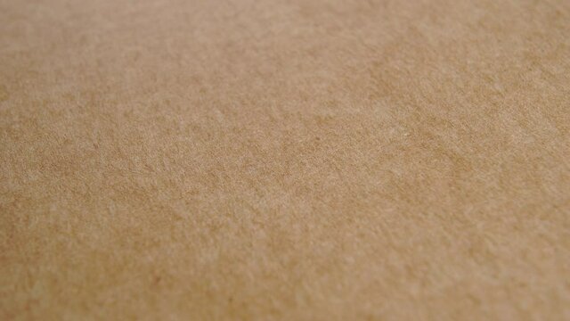 Kraft brown paper texture. Recycled cardboard. Rough textured sheet. Macro. Rotation