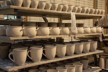 Unique handcrafted ceramic jugs and mugs before firing 