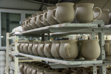 Unique handcrafted ceramic jugs and mugs before firing 