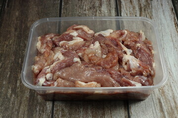 Pile of raw marinated pork meat in the plastic container. Preparation food concept. 