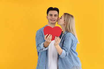 Fototapeta na wymiar Cute couple with heart on yellow background