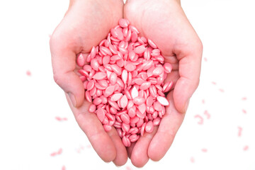 pink depilatory wax in granules, in hands