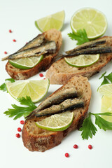 Delicious sandwiches with sprats on white background