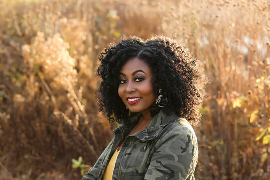 Portrait of a beautiful African female with curly hair on the nature background