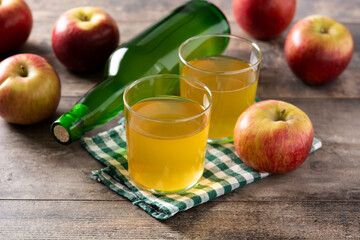 Apple cider drink on rustic wooden table.