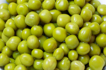 Food vegetable background. Canned green peas close-up. Source of vitamin K, C, D, E, A and B6, amino acids, potassium, antioxidants, folic acid, protein