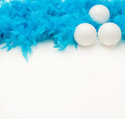 Christmas white background with blue tinsel, christmas ball and light glare