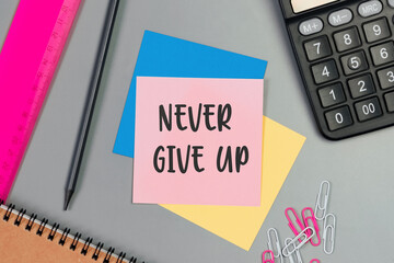 The words Never give up written on a sticky note paper. Closeup of a personal agenda. Top view. Conceptual photo