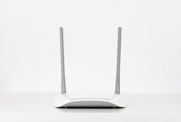 new white Wi fi router on a table against a white wall with a copy space front view