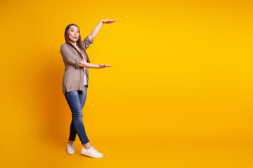 Full body profile side photo of young charming lady show hands measure size ads isolated over yellow color background