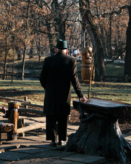 A lonely grandfather is standing in the park and thinking about something