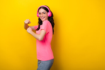 Profile side photo of young pretty lady have fun dancing club listen music earphones isolated over yellow color background